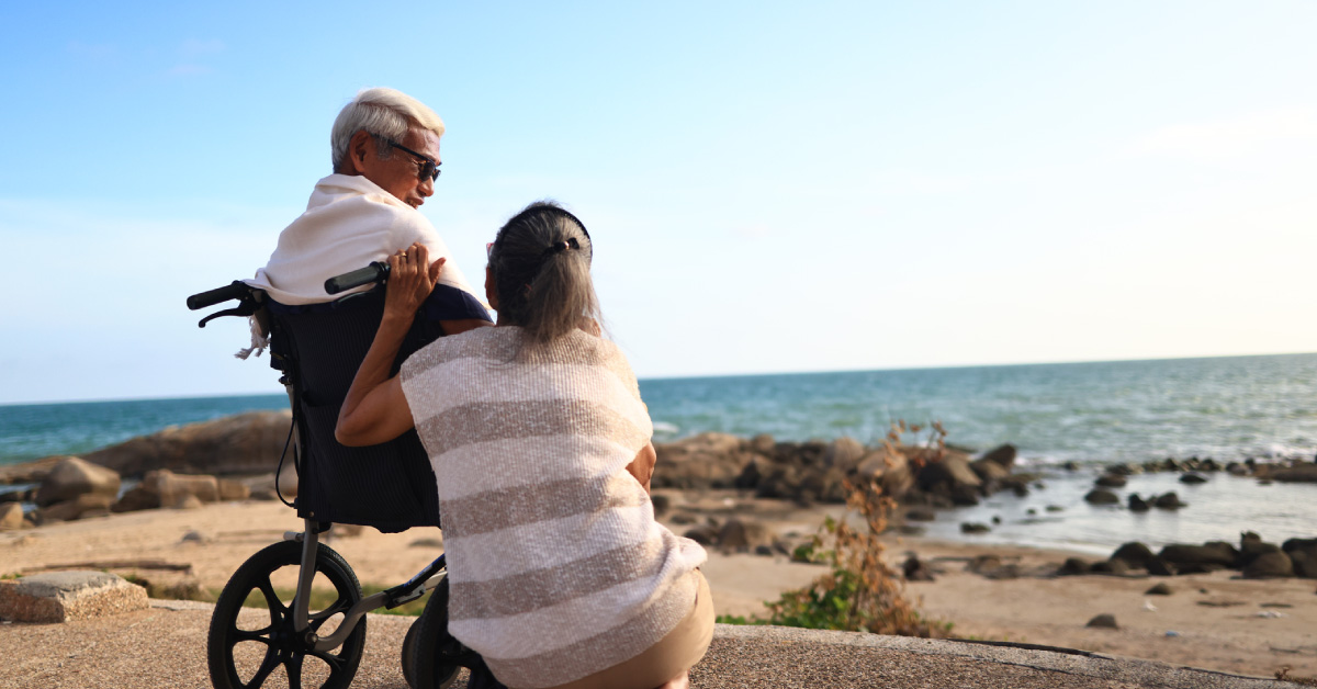 Man in wheelchair takes a holiday with his wife using the pay-out from his critical illness insurance