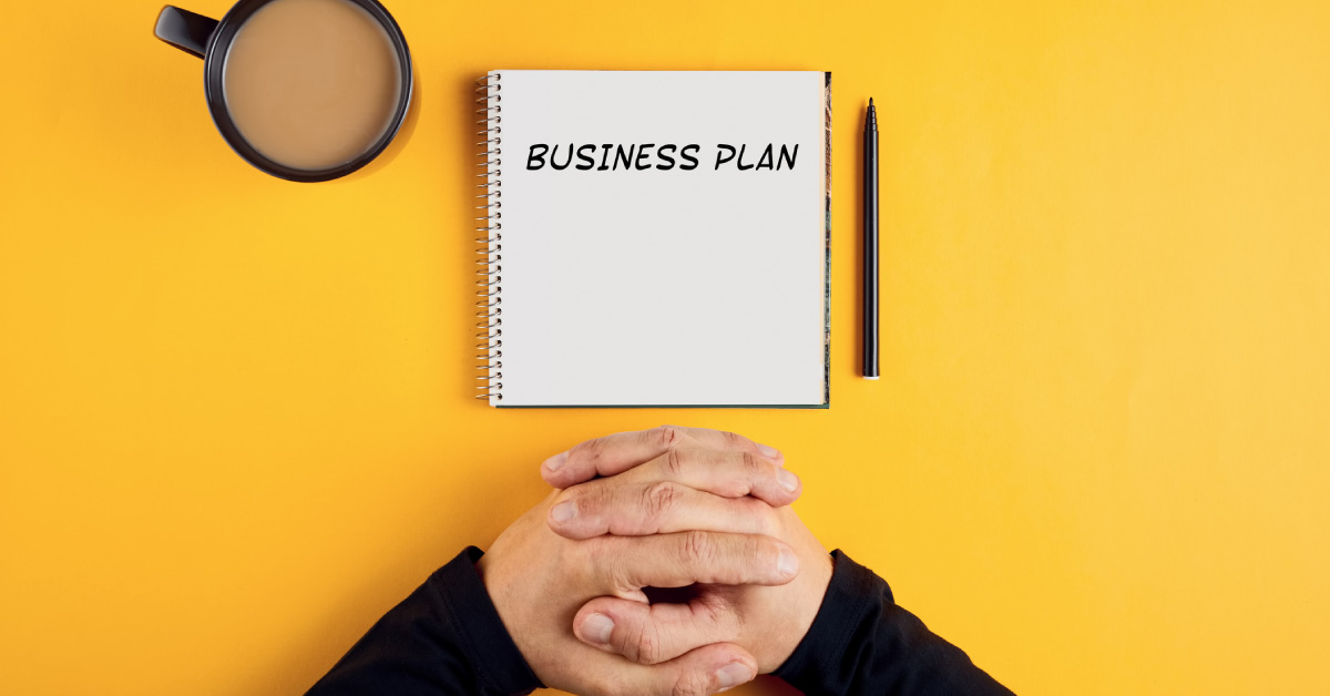hands-of-a-businessman-with-spiral-notebook-with-business-plan-ideas-ready